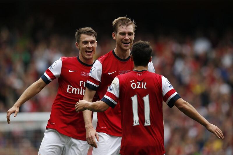 Arsenal midfielder Mesut Ozil, right, celebrates after Arsenal's Per Mertesacker scored against Stoke. Adrian Dennis / AFP