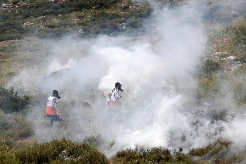 Palestinian medics run away from teargas used by Israeli troops during a protest marking the 72nd anniversary of Nakba and against Israeli plan to annex parts of the occupied West Bank, in the village of Sawiya near Nablus May 15, 2020. Reuters