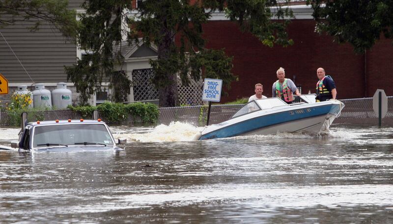 A motorboat passes a submerged pickup truck on Main St. in Washingtonville, N.Y., Sunday Aug. 28, 2011 following heavy rains. Stripped of hurricane rank, Tropical Storm Irene spent the last of its fury Sunday, leaving treacherous flooding and millions without power. (AP Photo/Paul Kazdan) *** Local Caption ***  Irene.JPEG-0a74a.jpg
