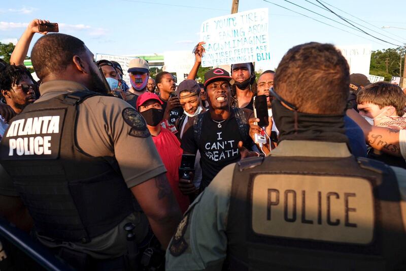 Protesters confront police officers near Centennial Olympic Park in Atlanta inresponse to the death of Rayshard Brooks. AP