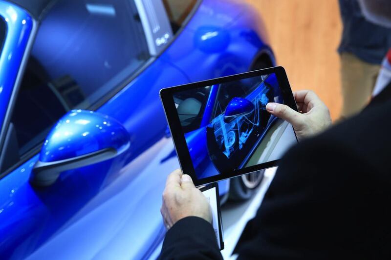 A tablet uses augmented reality to show the inside of a Porsche car at the CeBit 2017 tech fair in Germany. The technology, says Apple’s chief executive Tim Cook, has an advantage over virtual reality because it does not involve sensory-depriving headgear. Krisztian Bocsi / Bloomberg