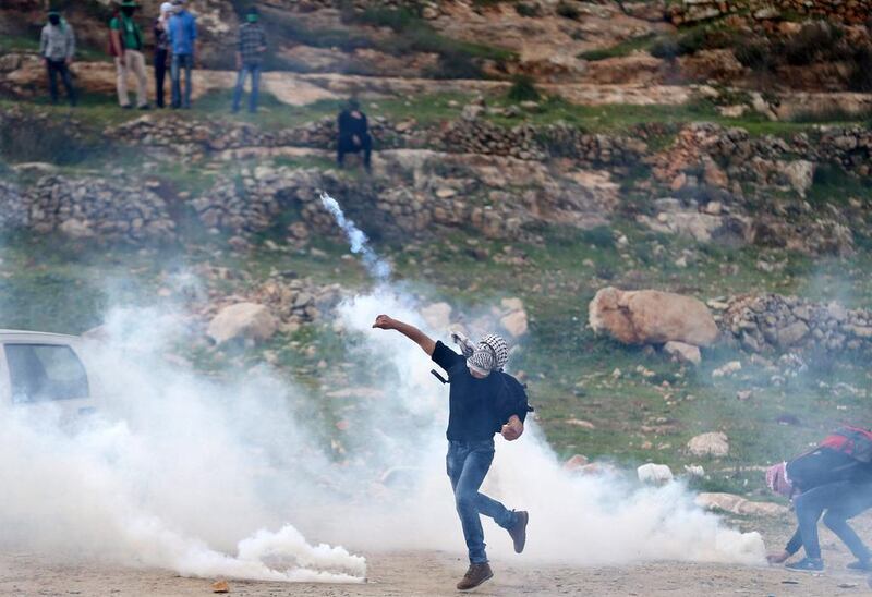 A Palestinian protester hurls back a tear gas canister fired by Israeli troops during clashes near Israel's Ofer Prison near the West Bank city of Ramallah, March 7, 2017. REUTERS/Mohamad Torokman 