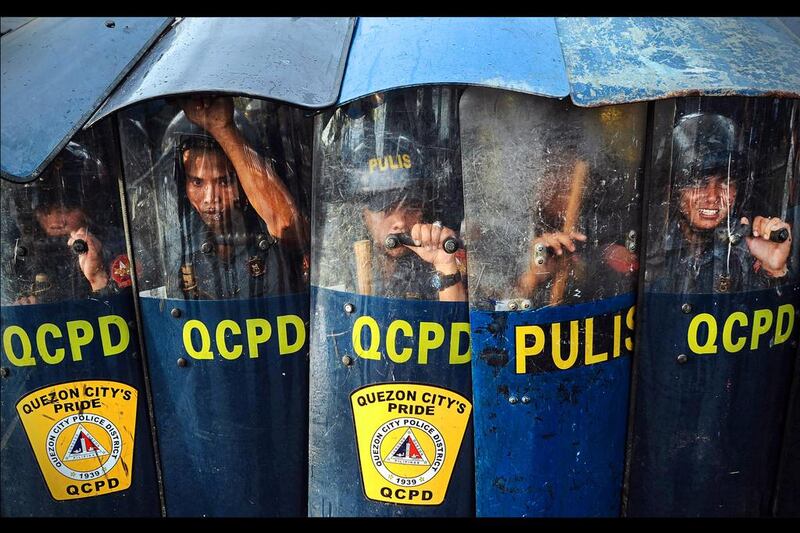 Police civil disturbance teams block a road leading to the House of Representatives during Philippine president Benigno Aquino IV's annual state of the nation address in Manila. Dondi Tawatao / Getty Images