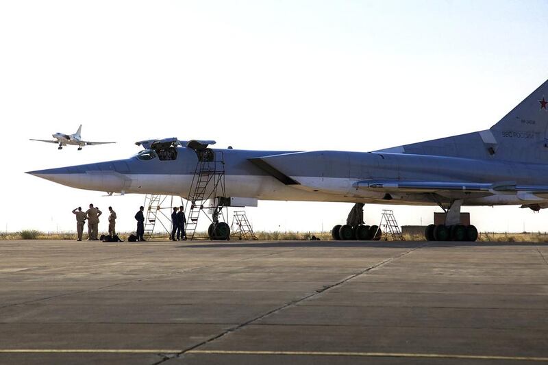 A Russian Tu-22M3 bomber stands on the tarmac while another plane lands at an air base near Hamedan, Iran. WarfareWW Photo via AP