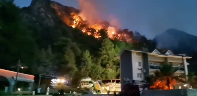 Vegetation burns behind a hotel in Icmeler, near Marmaris.