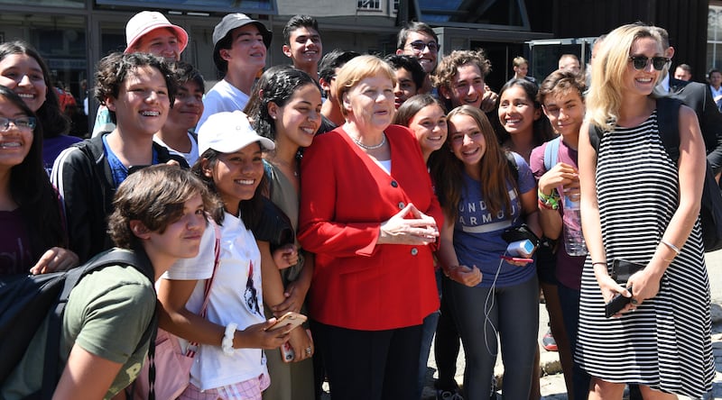 German Chancellor Angela Merkel with some of the schoolchildren who have grown up during her long rule. AFP