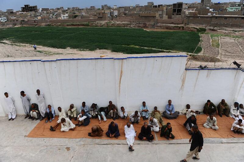 A view of Herat city is seen in the background while patients rest behind a wall in the rehabilitation centre.