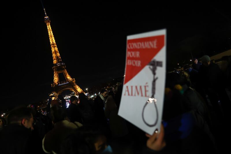 A protester holds a sign reading 'condemned for loving' during a display of the words '#StopExecutionsInIran' on the Eiffel Tower in Paris, France, 16 January 2023. EPA