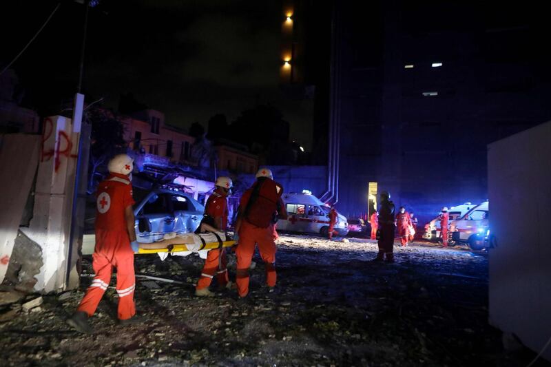 Lebanese Red Cross officers carry an injured woman following an explosion at the port of Beirut. AFP