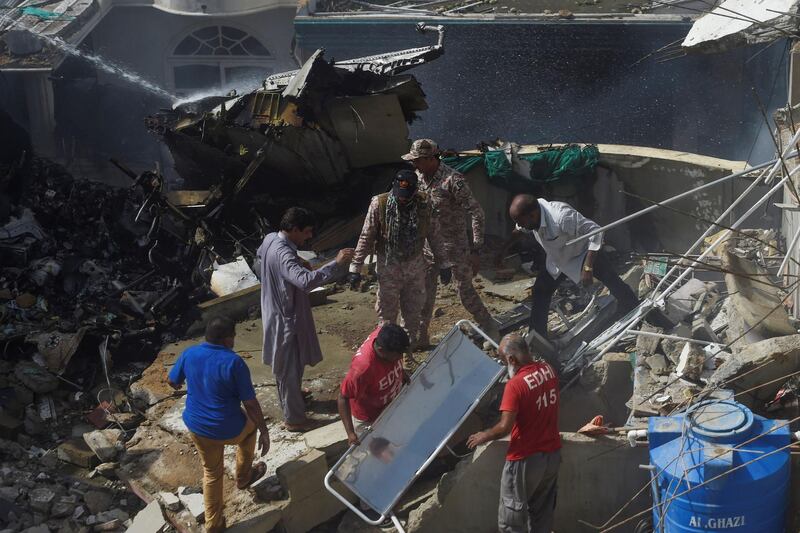 Rescue workers gather at the site after a Pakistan International Airlines flight crashed in a residential neighbourhood in Karachi. AFP