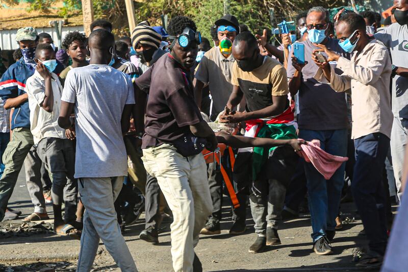 Protesters carry away a wounded person. At least 48 people have died in crackdowns during weeks of demonstrations, the Sudanese Doctors' Committee has said.  EPA