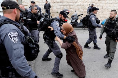 TOPSHOT - An Israeli policeman pushes back a Palestinian woman outside the Old City of Jerusalem after Israeli forces closed the entrance to al-Aqsa mosque compound on March 12, 2019. / AFP / AHMAD GHARABLI
