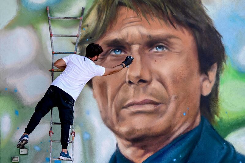 Street artist Luciano Ranieri creates a large mural of the new SSC Napoli coach Antonio Counte, in Naples, Italy.  EPA