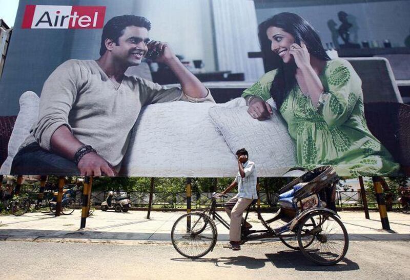 A rickshaw driver talks on his mobile phone as he rides past a billboard outside a railway station in the northern Indian city of Chandigarh: Retailers, telecoms companies and other businesses are heading out of the cities in pursuit of growth among the 742 million Indians who live there.