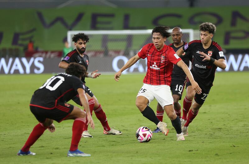 Urawa's Takahiro Akimoto dribbles through Al Ahly players. AP