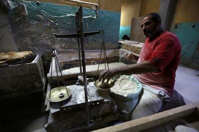 FILE PHOTO: A worker weighs dough to be baked into bread at a bakery in Cairo, January 8, 2015. REUTERS /Mohamed Abd El Ghany/File Photo