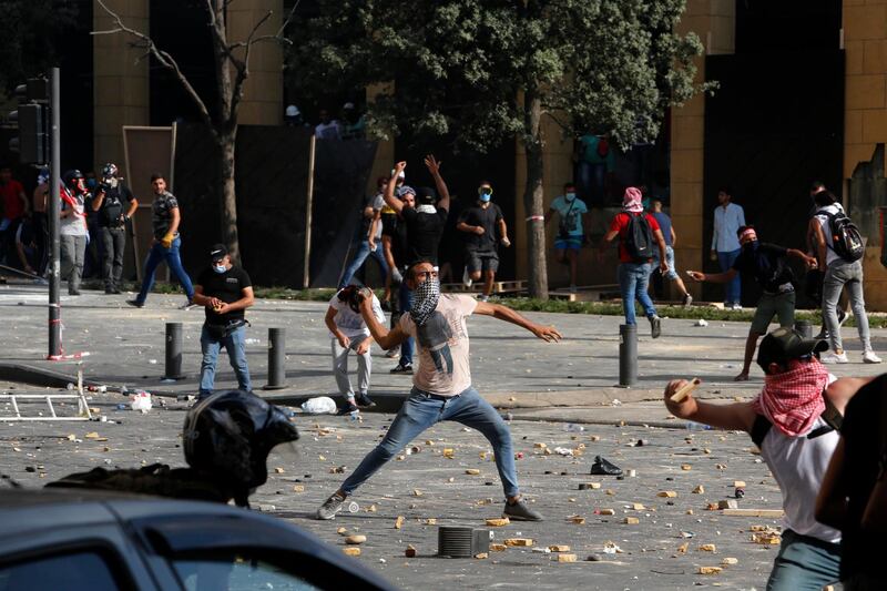 BEIRUT, LEBANON - AUGUST 08: Protesters throw stones during an anti-government demonstrations on August 8, 2020 in Beirut, Lebanon. The Lebanese capital is reeling from this week's massive explosion that killed at least 150 people, wounded thousands, and destroyed wide swaths of the city. Residents are demanding accountability for the blast, whose suspected cause was 2,700 tons of ammonium nitrate stored for years at the city's port. (Photo by Marwan Tahtah/Getty Images)