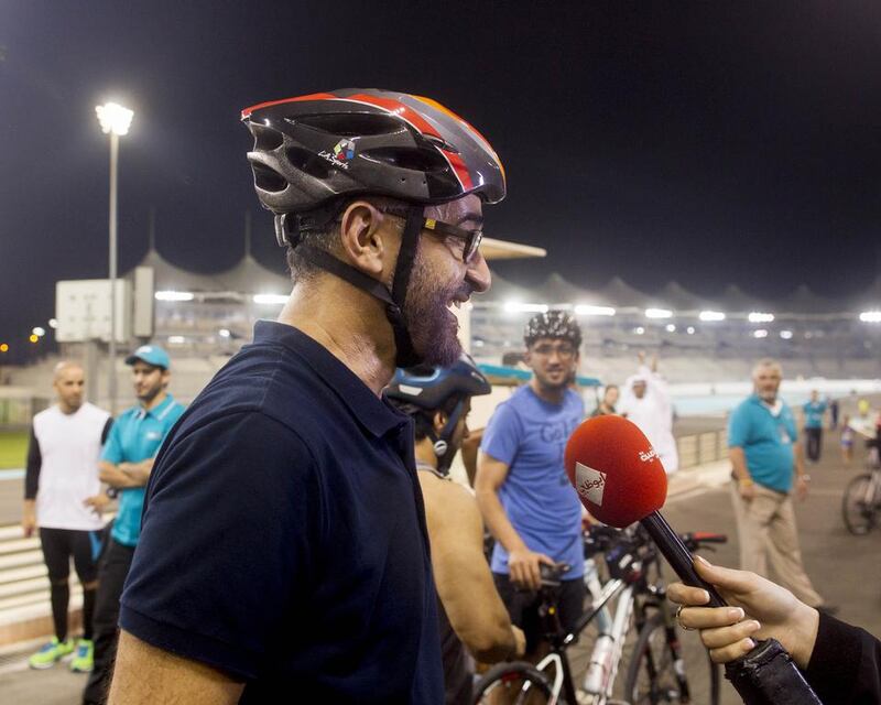 Sheikh Mohammed bin Zayed, centre, speaks to the media after riding his bicycle around Yas Marina Circuit during the weekly TrainYAS event in October. Ryan Carter / Crown Prince Court — Abu Dhabi 