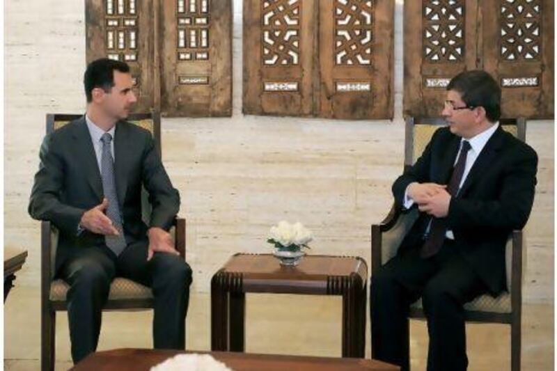 The Syrian president, Bashar al Assad, left, meets the Turkish foreign minister, Ahmet Davutoglu, right, in Damascus on the eve of the Baath party's 64th anniversary.