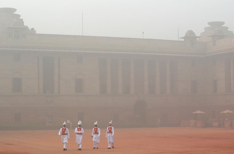 Indian presidential staff members walk surrounded by smog at the presidential palace in New Delhi, India, Tuesday, Nov. 7, 2017. Air pollution in India's capital has hit hazardous levels prompting local officials to ask that school shut down and a half marathon scheduled later in November be called off. (AP Photo/Manish Swarup)