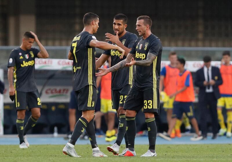 Juventus' Federico Bernardeschi, right, celebrates with teammates Cristiano Ronaldo and Emer Can, center, after scoring his side's 3rd goal, during the Serie A soccer match between Chievo Verona and Juventus, at the Bentegodi Stadium in Verona, Italy, Saturday, Aug. 18, 2018. (AP Photo/Antonio Calanni)