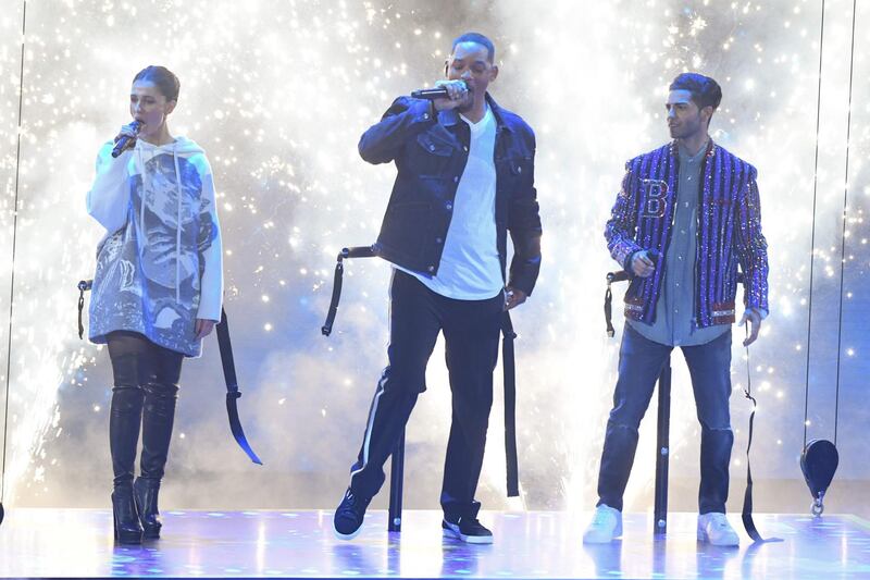 Actress Naomi Scott, left, Will Smith, centre, and Mena Massoud appear on stage. AFP