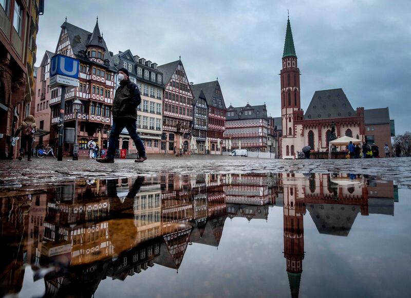 A man wears a face mask as he walks over the Roemerberg square in Frankfurt, Germany. AP Photo