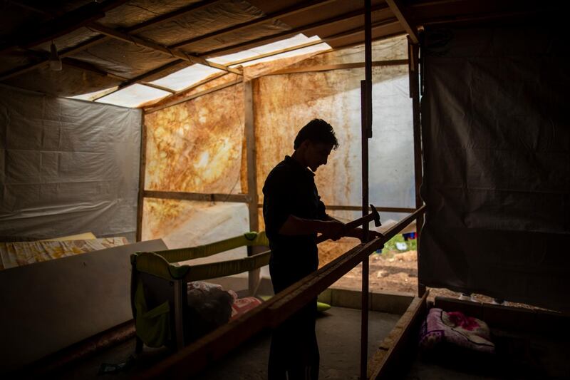 Syrian refugee Raed Mattar, 24, works on his tent at a makeshift refugee camp in the town of Rihaniyye in the northern Lebanese city of Tripoli. AP Photo