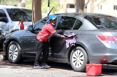 A worker washes a car in a residential community. Pawan Singh / The National     