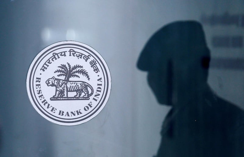 FILE PHOTO: A security guard's reflection is seen next to the logo of the Reserve Bank Of India (RBI) at the RBI headquarters in Mumbai, India, June 6, 2019. REUTERS/Francis Mascarenhas/File Photo