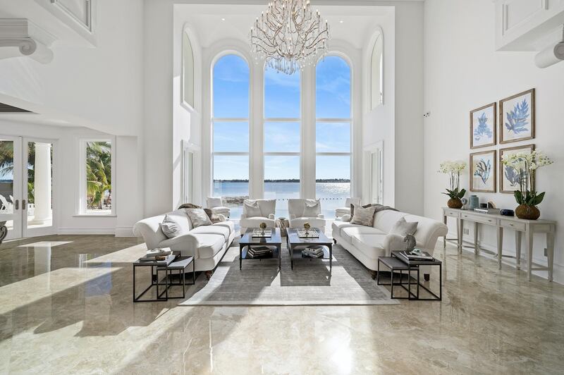 Floor-to-ceiling glass windows create a light and airy living space. Courtesy Sotheby’s International Realty