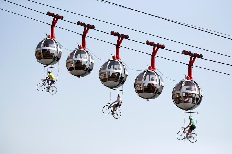 People dressed as cyclists hanging under the Grenoble Bastille cable cars ahead of Stage 17 of the Tour de France cycling race, on  Wednesday, September 16. EPA