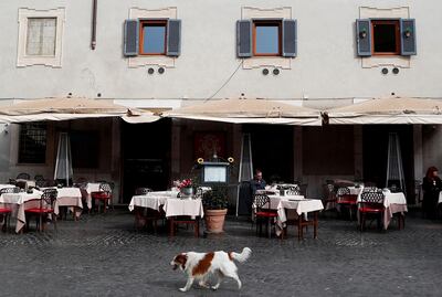 A dog passes in front of an almost empty restaurant in Trastevere area, after a decree orders for the whole of Italy to be on lockdown in an unprecedented clampdown aimed at beating the coronavirus,in Rome, Italy, March 10, 2020. REUTERS/Guglielmo Mangiapane     TPX IMAGES OF THE DAY