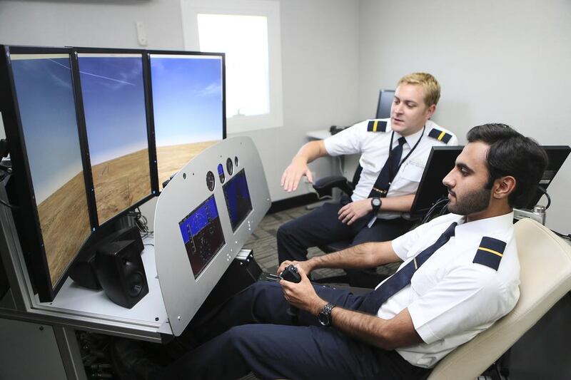 MPL instructor Luke Duvoisin, left, guides Emirati cadet pilot Mohammed Al Bloushi on a DiamondDA 42 flight simulator. Sarah Dea / The National