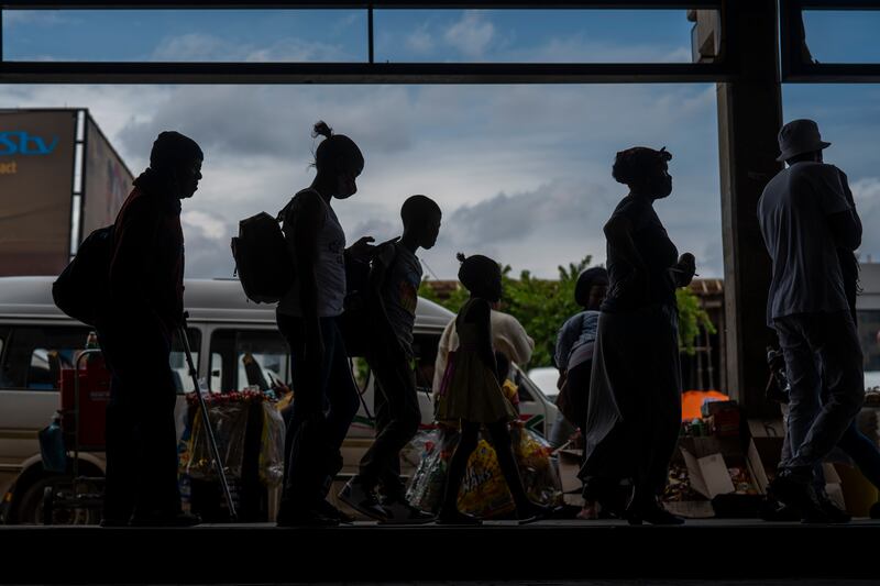 Passengers, some wearing masks, queue to board a taxi in Soweto, South Africa, a week after the Omicron variant was first detected in the country. AP