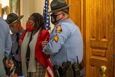 Democratic representative Park Cannon is placed in handcuffs after being asked to stop knocking on Governor Brian Kemp's office door as he signed the new voting law. AP