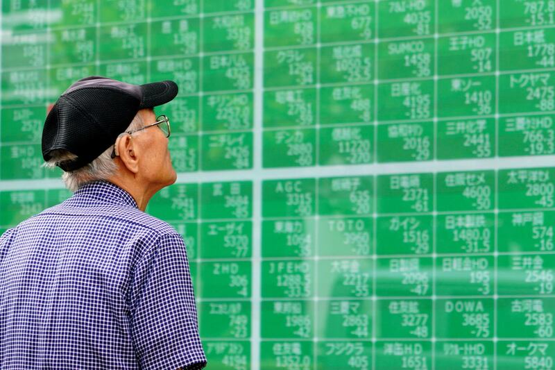 In this Oct. 3, 2019, photo, a man looks at an electronic stock board showing Japan's Nikkei 225 index at a securities firm in Tokyo. Asian shares were mostly higher Tuesday, Nov. 26, 2019 on optimism over U.S.-China trade talks, prompted by Beijingâ€™s new guidelines for the protection of patents and copyrights.  (AP Photo/Eugene Hoshiko)
