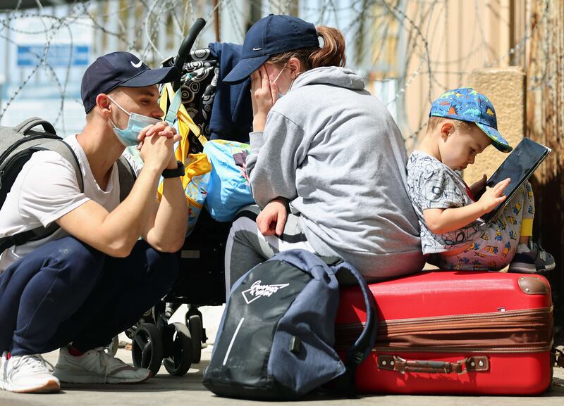 Russian asylum seekers Nastya, Artem and their son Samuil sit outside the San Ysidro Port of Entry after not being allowed to cross into the US to seek asylum on March 21, 2022 in Tijuana, Mexico.  The family left Russia after the Russian invasion of Ukraine began due to religious persecution.  Getty Images / AFP