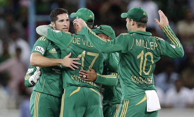 Wayne Parnell, left, celebrates with his South Africa teammates taking the wicket of Pakistan’s Mohammad Hafeez on Friday. Hassan Ammar / AP Photo