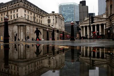 FILE PHOTO: The Bank of England and Royal Exchange are reflected in a puddle as a pedestrian walks past, amid the coronavirus disease (COVID-19) outbreak in London, Britain, November 19, 2020. REUTERS/Simon Dawson//File Photo