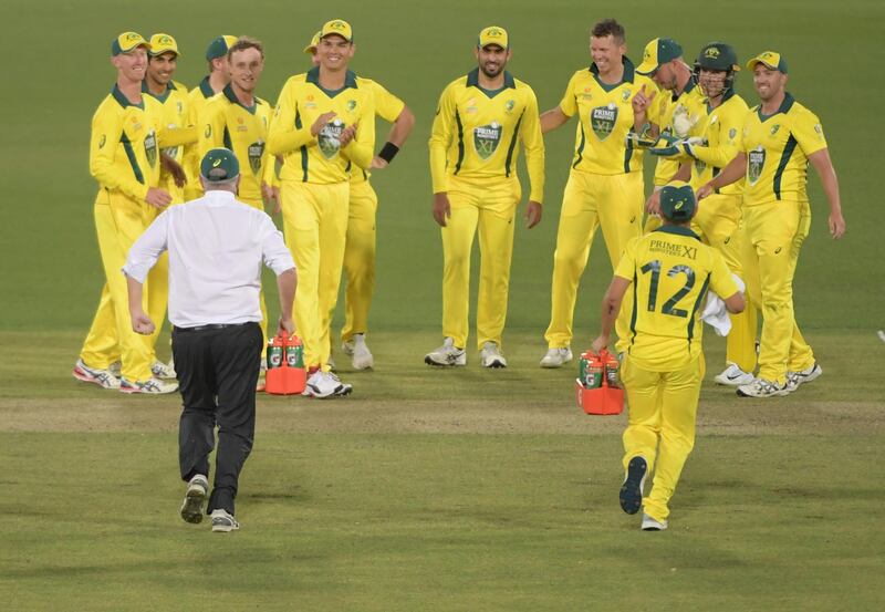 Australia Prime Minister Scott Morrison carries drinks during a break in the tour match between the PM XI and Sri Lanka at Manuka Oval in Canberra. Getty Images