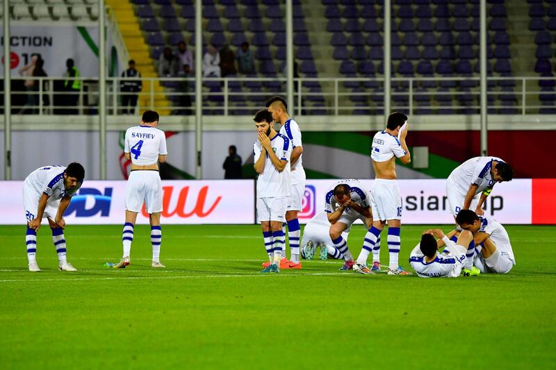 Uzbekistan players look dejected after the shoot-out defeat. AFP