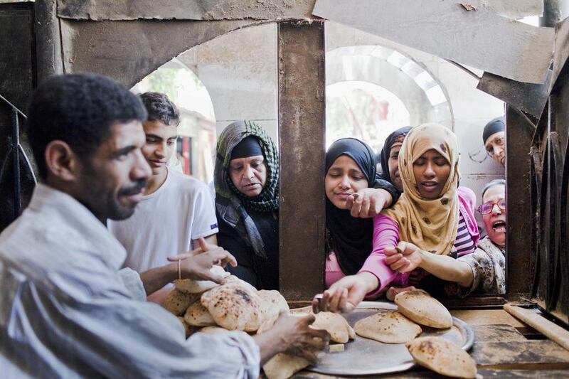 Women buy bread from a Cairo bakery. Egypt’s interim government has raised the public sector minimum wage and pensions, and the central bank has lowered its key interest rates by a full percentage point since August to encourage growth. Shawn Baldwin / Bloomberg via Getty Images

