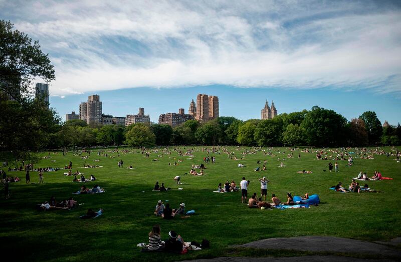 People sit on the grass in Central Park in New York City, amid the coronavirus pandemic.  AFP