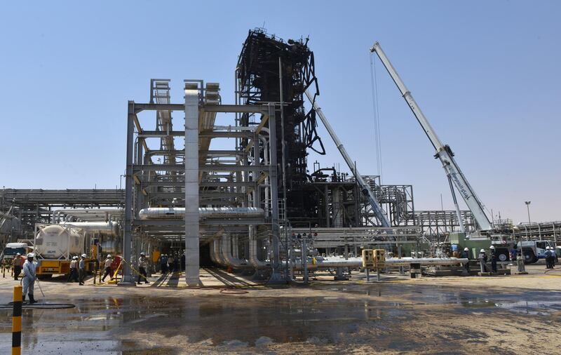 Employes of Aramco oil company stand near a heavily damaged installation in Saudi Arabia's Khurais oil processing plant on September 20, 2019. - Saudi Arabia said on September 17 its oil output will return to normal by the end of September, seeking to soothe rattled energy markets after attacks on two instillations that slashed its production by half. The strikes on Abqaiq –- the world's largest oil processing facility –- and the Khurais oil field in eastern Saudi Arabia roiled energy markets and revived fears of a conflict in the tinderbox Gulf region. (Photo by Fayez Nureldine / AFP)