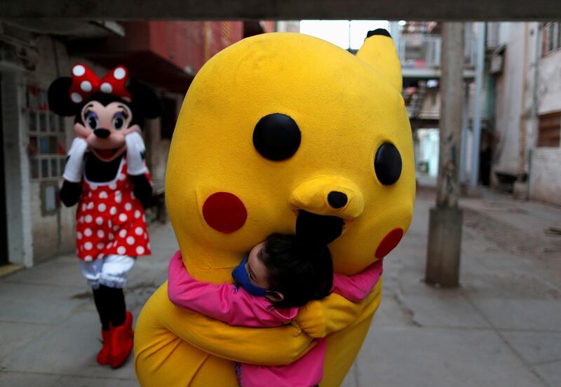 A volunteer wearing a costume of Pokemon character Pikachu hugs a child during Children's Day, amid the coronavirus disease (COVID-19) outbreak, in Fuerte Apache, in Buenos Aires, Argentina. REUTERS