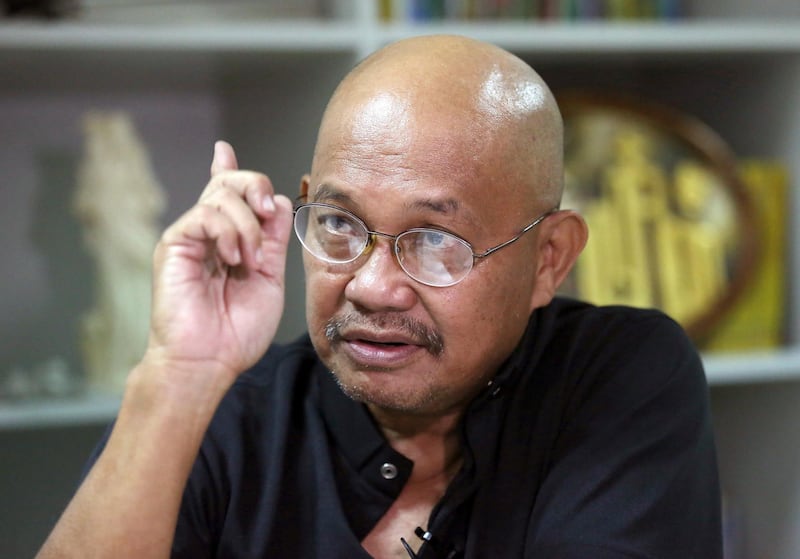 FILE - In this May 13, 2016, file photo, Filipino Catholic priest Father Amado Picardal gestures during an interview at the Catholic Bishops' Conference of the Philippines office in Manila, Philippines. Picardal, who is one of the earliest critics of the Philippine president's deadly crackdown on drugs, has gone into hiding due to what he says were signs that he's being targeted by motorcycle-riding hitmen. (AP Photo/Aaron Favila, File)