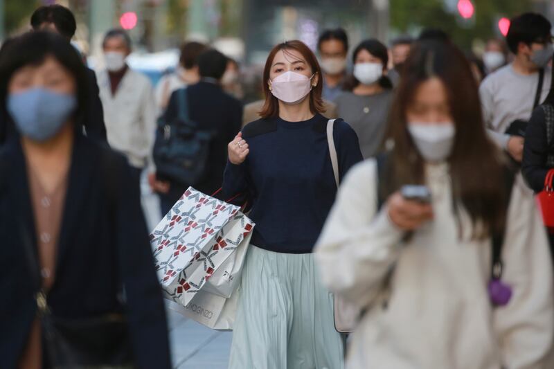 People wearing face masks to help curb the spread of the coronavirus walk at the Ginza shopping district in Tokyo. Spending in the Asian country has ballooned due to an array of payouts, including cash handouts to households with youth aged 18 or below. AP Photo / Koji Sasahara
