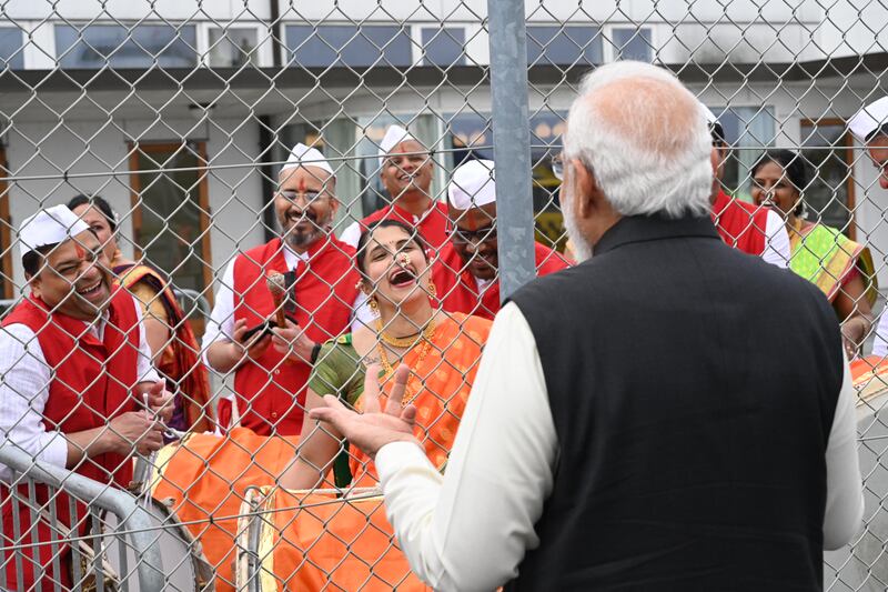 The Indian prime minister greets members of a band after he landed at Copenhagen Airport. AFP