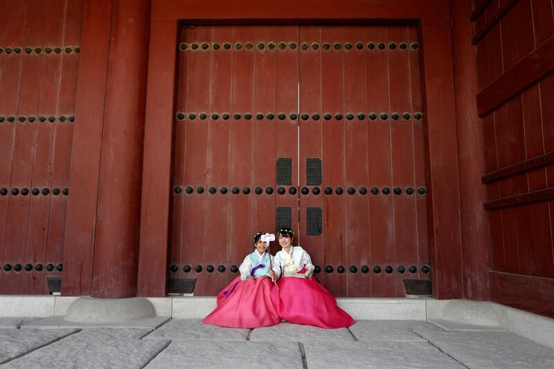 Tourists wearing the traditional hanbok Korean costume pose for a selfie during a tour of the Gyeongbok Palace in Seoul, South Korea. Jeon Heon-Kyun/EPA